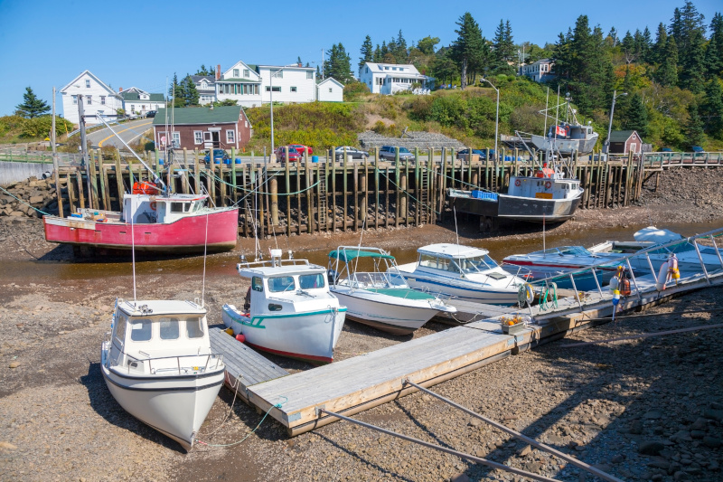 Low tide showing fishing boats and the dock resting on the seafloor at Hall's Harbour on the Bay of Fundy, Nova Scotia