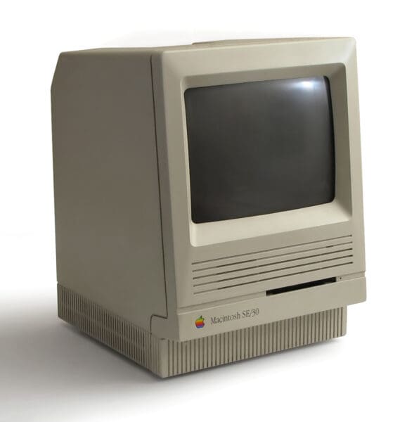 Fotografía de estudio auténtica de un ordenador Macintosh SE/30 clásico, que destaca su icónico diseño de escritorio.