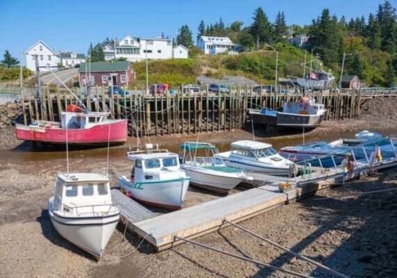 Na maré baixa, é possível ver os barcos de pesca e o cais apoiados no fundo do mar em Hall's Harbour, na Baía de Fundy, Nova Escócia.